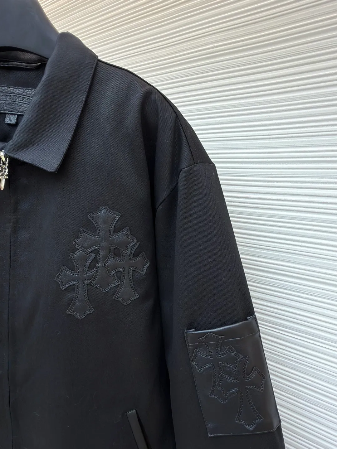 Chrome Hearts solid color logo patch lapel jacket ●Original version: purchased and developed by 13730 ●Item number: 1681764-B75 ●Fabric: leather fabric ●Technology: patch production ●Color: black ●Version: fitted version ●Weight: about 1020 grams ●Size: S-M-L-XL ●Description: Made of high-density matte fabric, treated with anti-wrinkle shaping technology, it has both stiffness and drape texture, smooth touch and not easy to pilling. The body is decorated with the brand's iconic cross embroidery, which is created through three-dimensional quilting embroidery technology. The pattern is full of layers and clear texture, which is both recognizable and refined. The cuffs are spliced ​​with leather labels and fixed by heat-pressing lamination technology to enhance texture and durability. The version is loosely cut, with metal zipper + decorative pendant, which makes it easy to put on and take off and enhances the details; the cuff button adjustment design adapts to different arm circumferences, and the hem is naturally edged to ensure a neat fit. The stitching of the whole garment is neat, with no exposed threads at the splicing points. The size is measured manually (an error of 1-3CM is normal). The craftsmanship balances the dark style and practical wearability. It is a single product with both styling and practicality. The overall wiring is straight and delicate, the fabric is comfortable and soft, and the color is consistent without color difference. It can be matched with the same style to create a fashionable look and control various occasions. Customized accessories, complete with three standards, same style for men and women!